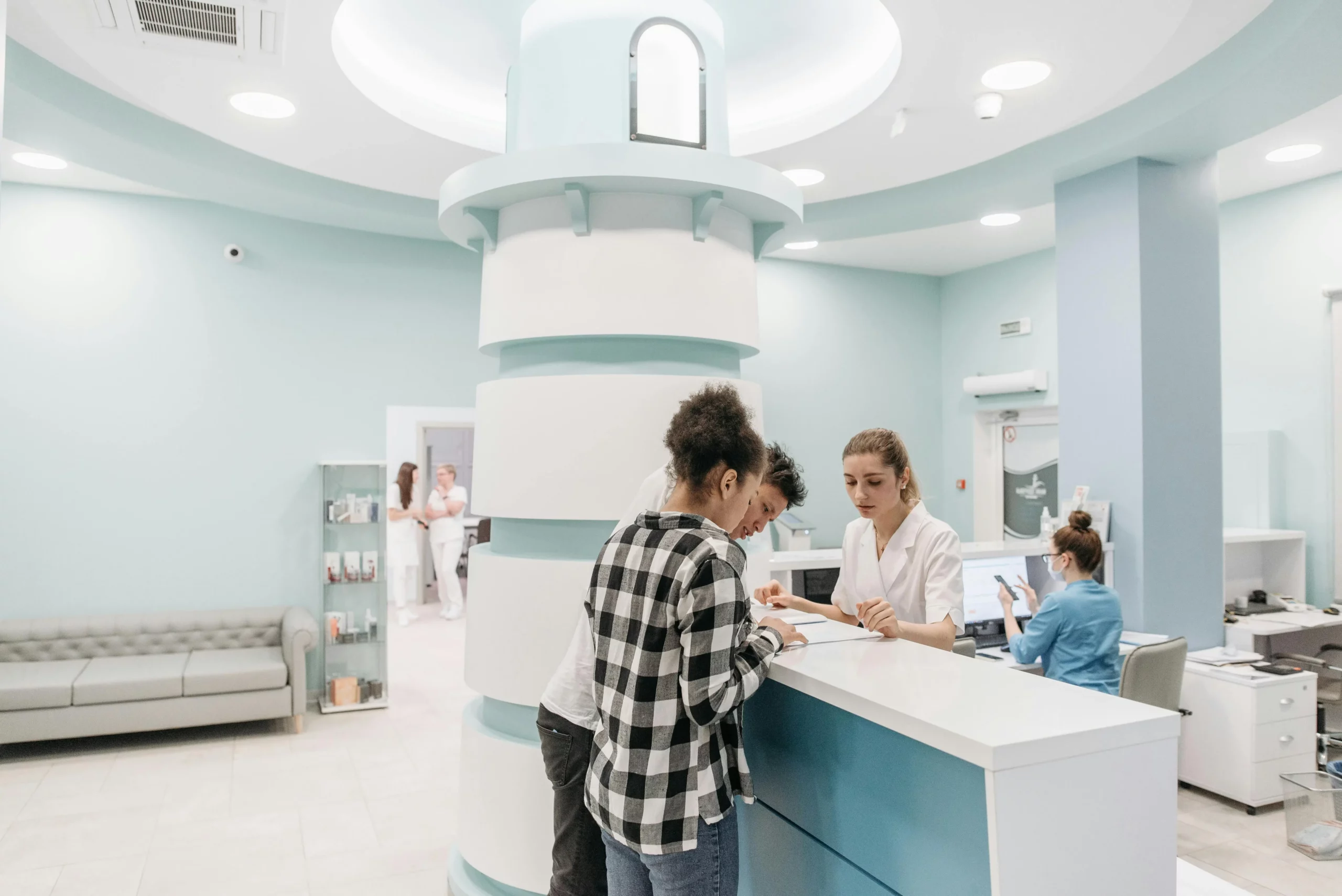 Ärzte und Patienten am Tresen in einer hell-beleuchteten Klinik in Deutschland